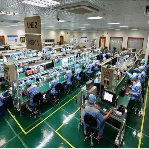 Assembly line in industrial setting with workers, showcasing use of Top Notch Pneumatic Pressure Controlled Vacuum Generator Valves