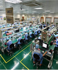 Workers in a factory assembling products at manufacturing line, highlighting industrial production environment.
