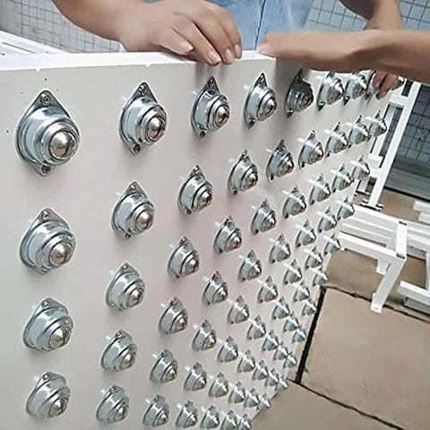 Hands installing 16 Pcs 1/2 Inch Roller Ball Transfer Bearings Flange Mounted Carbon Steel Units on conveyor system panel.